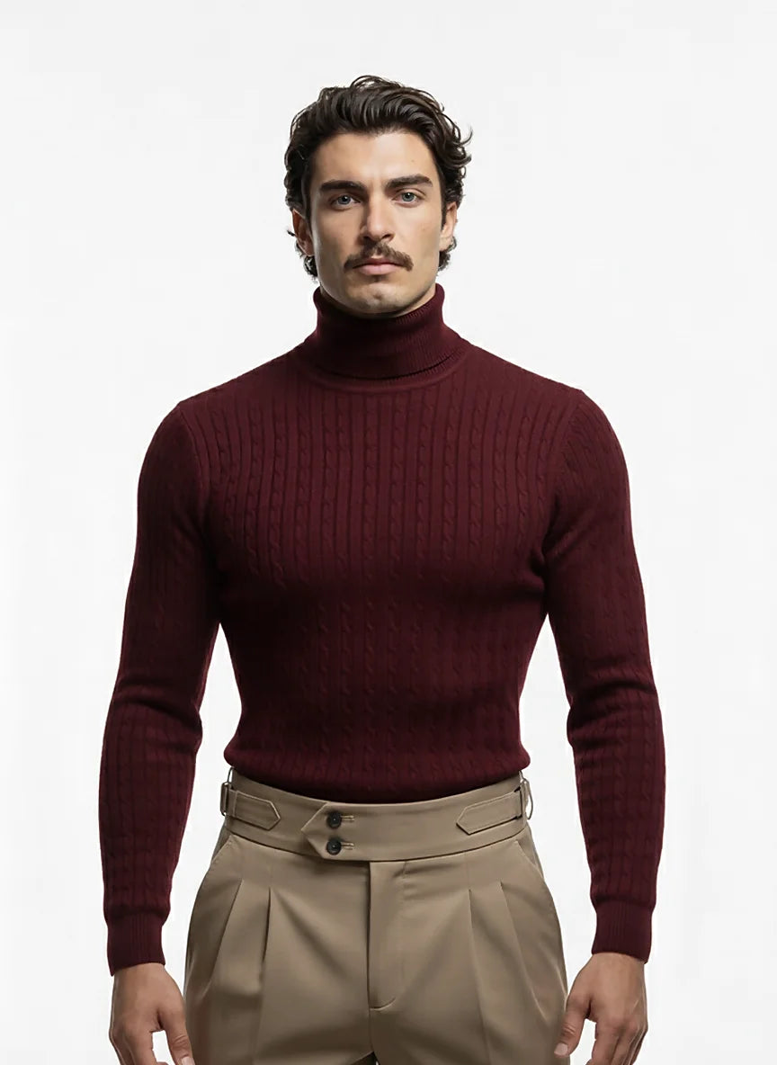 Man wearing a maroon turtleneck sweater and beige pants on a white background
