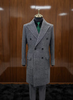 Gray overcoat on a mannequin against a wooden wall.