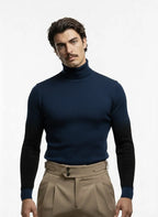 Man wearing a navy turtleneck sweater and beige pants on a white background