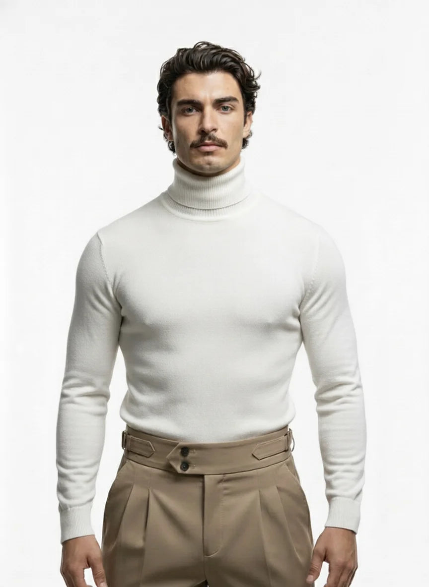 Man wearing a white turtleneck sweater and beige pants on a white background
