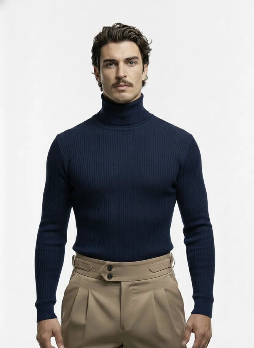 Man wearing a navy turtleneck sweater and beige pants on a white background