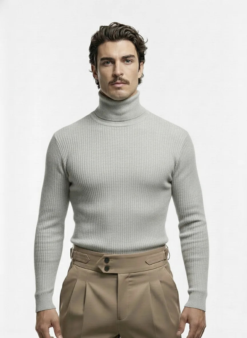 Man wearing a light gray turtleneck sweater and beige pants on a white background
