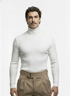 Man wearing a white turtleneck sweater and beige pants on a white background