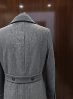 Gray coat on a mannequin against a wooden background